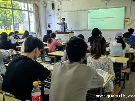 A group of people sitting at desks in a classroom  AI 生成的内容可能不正确。